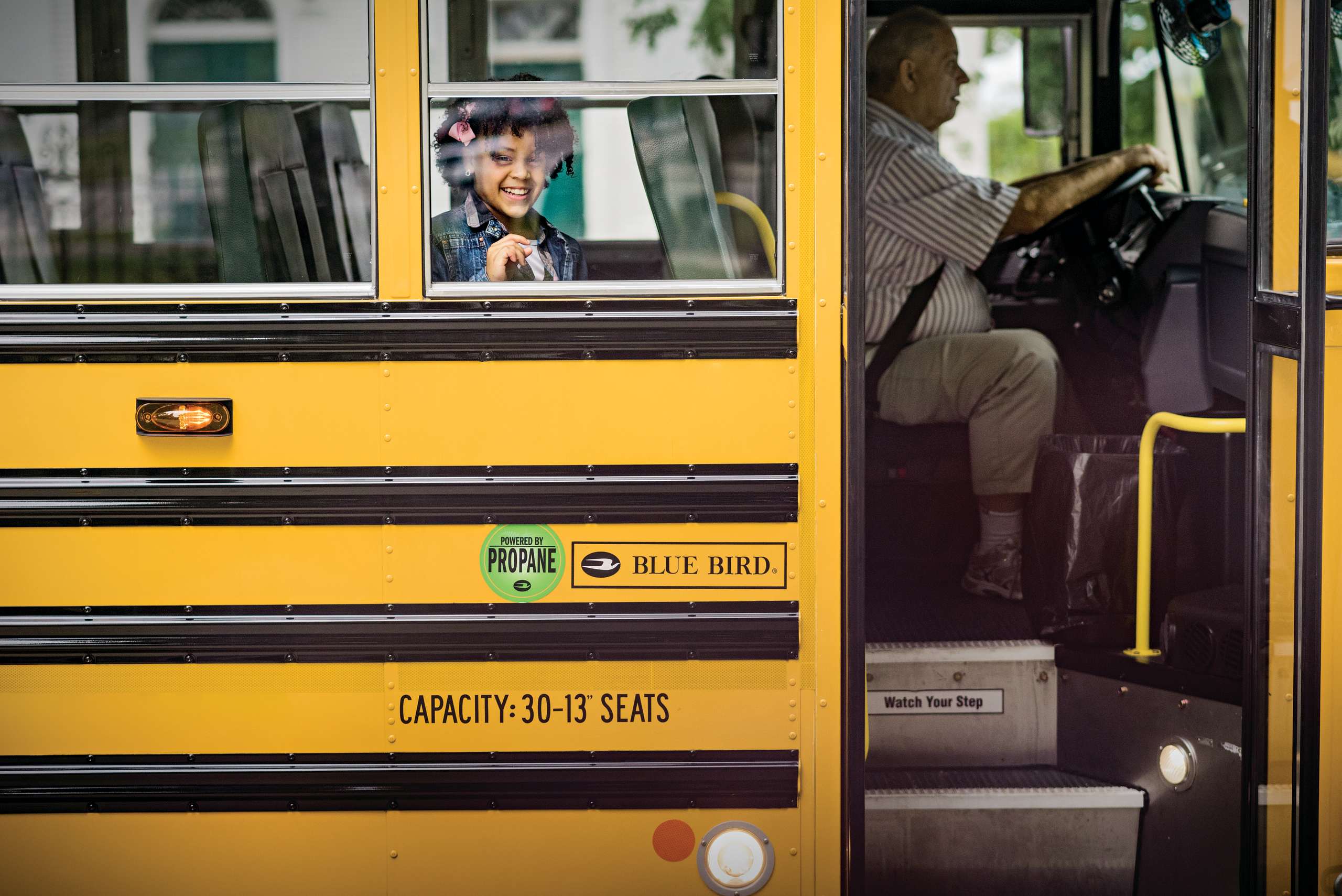 Child looking out the window on a school bus
